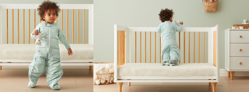 Toddler standing up in crib, holding railing