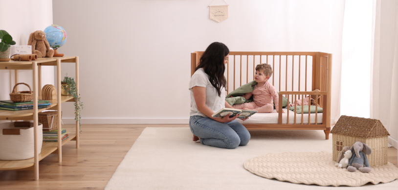 Toddler in cot next to his parent